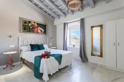 a white bedroom with a bed and a table at Catedral Moderno Centro in Jerez de la Frontera
