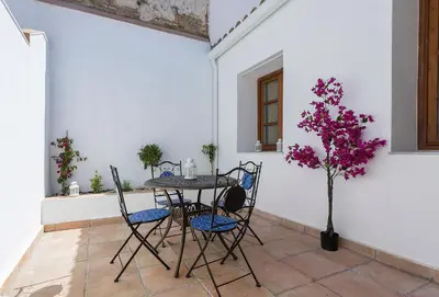 a table and chairs on a patio with a tree at Catedral Moderno Centro in Jerez de la Frontera