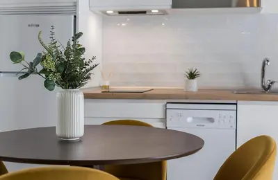 a kitchen with a table with a vase on it at Catedral Moderno Centro in Jerez de la Frontera