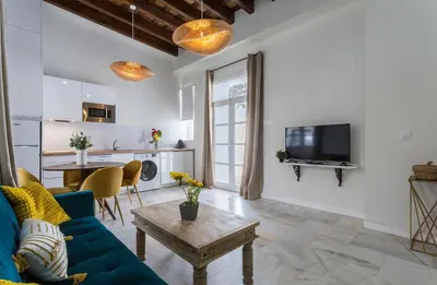 a living room with a blue couch and a table at Catedral Moderno Centro in Jerez de la Frontera