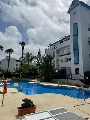 a swimming pool in front of a building at Apartamento en Playa Ballena III in Rota