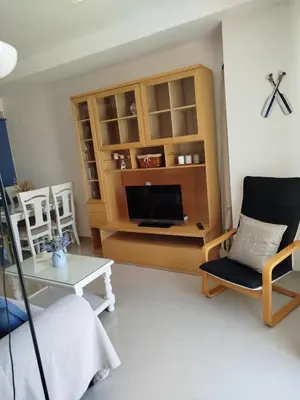 a living room with a tv and a chair and a table at Apartamento en Playa Ballena III in Rota