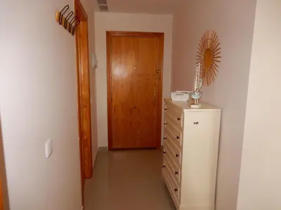 a room with a dresser and a wooden door at Apartamento en Playa Ballena III in Rota
