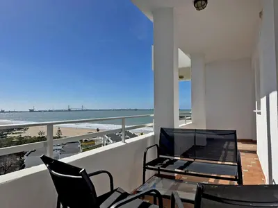 a balcony with a table and chairs and a view of the beach at Apartamento Brisa & Mar in El Puerto de Santa María