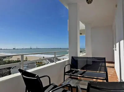 a balcony with a table and chairs and a view of the beach at Apartamento Brisa & Mar in El Puerto de Santa María