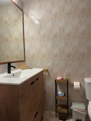 a bathroom with a sink and a mirror and a toilet at Apartamento Brisa & Mar in El Puerto de Santa María