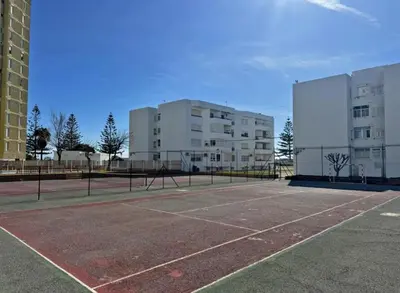 a tennis court in front of some buildings at Apartamento Brisa & Mar in El Puerto de Santa María
