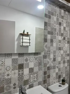a bathroom with a toilet and a tiled wall at El Encanto de Jerez in Jerez de la Frontera