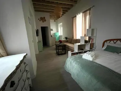 a bedroom with a bed and a living room at El Encanto de Jerez in Jerez de la Frontera