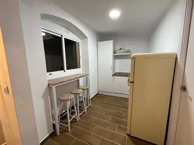 a kitchen with a refrigerator and stools in it at El Encanto de Jerez in Jerez de la Frontera