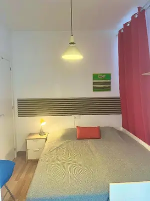 a bedroom with a large bed with a red curtain at Vista Plaza Falla in Cádiz