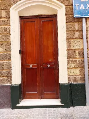 a brown wooden door in a brick building at Vista Plaza Falla in Cádiz