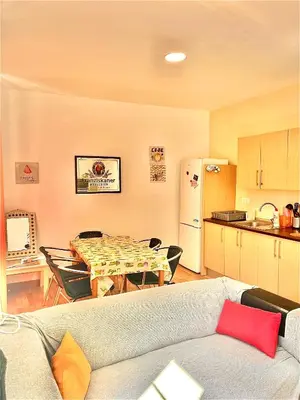 a living room with a couch and a table and a kitchen at Vista Plaza Falla in Cádiz