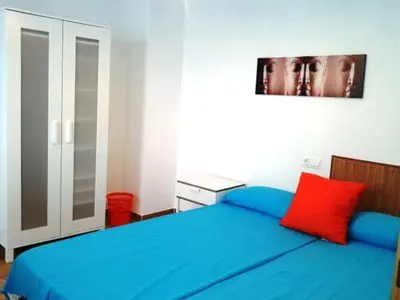 a bedroom with a blue bed with a red pillow at Vista Plaza Falla in Cádiz