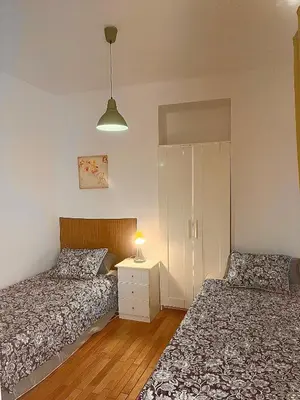 a bedroom with two beds and a table with a lamp at Vista Plaza Falla in Cádiz