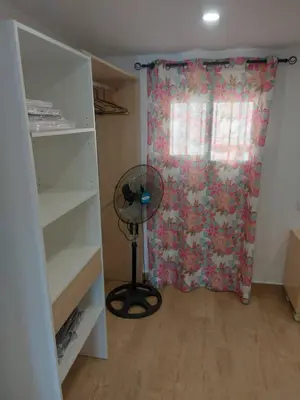 a room with a fan in front of a window at Casa con patio in Sanlúcar de Barrameda