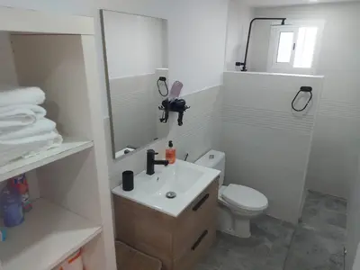 a white bathroom with a sink and a toilet at Casa con patio in Sanlúcar de Barrameda