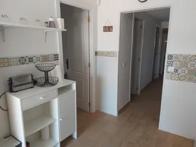 a room with a white cabinet and a hallway at Casa con patio in Sanlúcar de Barrameda