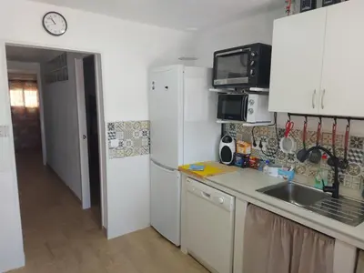 a kitchen with a white refrigerator and a sink at Casa con patio in Sanlúcar de Barrameda