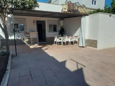 a patio with a table and chairs in a house at Casa con patio in Sanlúcar de Barrameda