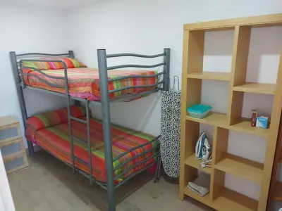 a room with two bunk beds and a shelf at Casa con patio in Sanlúcar de Barrameda