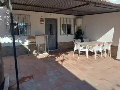 a patio with a table and chairs in a house at Casa con patio in Sanlúcar de Barrameda