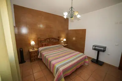 a bedroom with a bed with a striped blanket at Casa Ana Mari in Conil de la Frontera