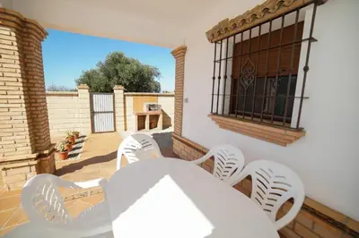 a white table and chairs on a patio at Casa Ana Mari in Conil de la Frontera