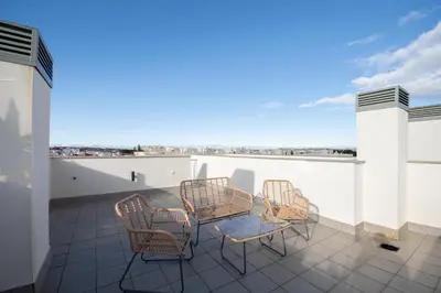 a patio with chairs and a table on a roof at APARTOYOU Apartments - Oasis El Puerto in El Puerto de Santa María