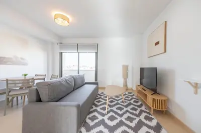 a living room with a couch and a television at APARTOYOU Apartments - Oasis El Puerto in El Puerto de Santa María