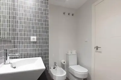 a bathroom with a white sink and a toilet at APARTOYOU Apartments - Oasis El Puerto in El Puerto de Santa María