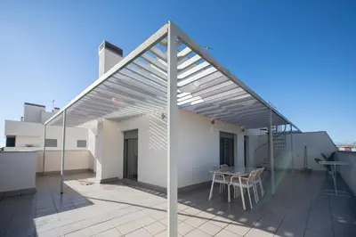a patio with awning on top of a building at APARTOYOU Apartments - Oasis El Puerto in El Puerto de Santa María