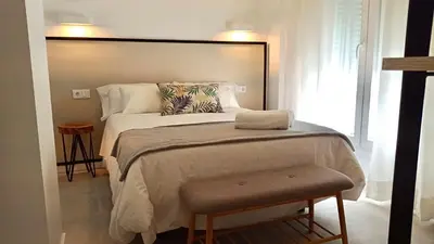 a bedroom with a bed with a large headboard at El Patio de mama Carmen by RentCadiz in El Puerto de Santa María