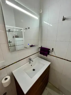 a white bathroom with a sink and a mirror at Villa María Cádiz centro, 