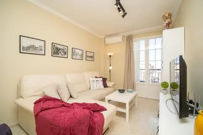 a living room with a white couch and a table at Sibs Sanlucar RIOMAR-Renovado Centrico vistas in Sanlúcar de Barrameda