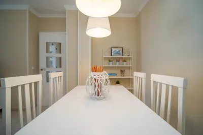 a dining room with a white table with a vase on it at Sibs Sanlucar RIOMAR-Renovado Centrico vistas in Sanlúcar de Barrameda