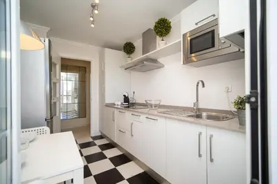 a kitchen with white cabinets and a checkered floor at Sibs Sanlucar RIOMAR-Renovado Centrico vistas in Sanlúcar de Barrameda