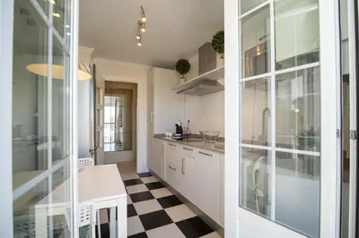 a kitchen with white cabinets and a checkered floor at Sibs Sanlucar RIOMAR-Renovado Centrico vistas in Sanlúcar de Barrameda
