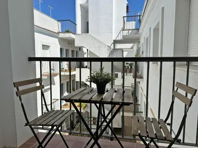 a balcony with a wooden table and two chairs at Apartamento Cielo in El Puerto de Santa María