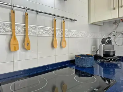 a kitchen with wooden spoons hanging on the wall at Apartamento Cielo in El Puerto de Santa María