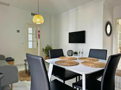 a dining room with a white table and chairs at Apartamento Cielo in El Puerto de Santa María