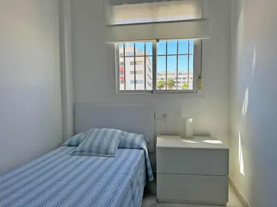 a small bedroom with a bed and a window at Apartamento Cielo in El Puerto de Santa María