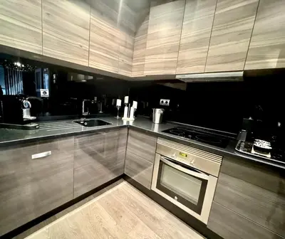 a kitchen with wooden cabinets and a stove top oven at Terra Boutique Cádiz in Cádiz