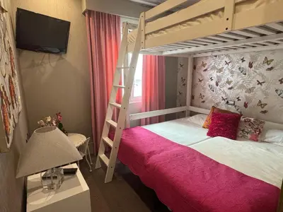a bedroom with a bunk bed with a pink bedspread at Terra Boutique Cádiz in Cádiz