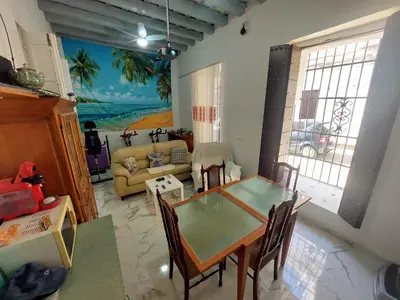 a living room with a table and a couch at Casa Madre Gelart Patrimonio Gaditano del siglo XIX in San Fernando