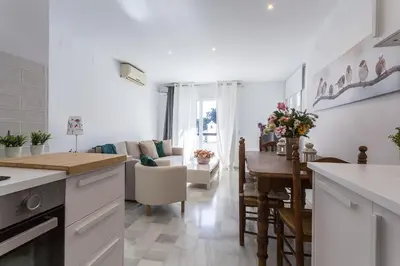 a kitchen and living room with a table and chairs at Vistahermosa 2 Rooms Piscina in El Puerto de Santa María