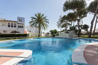 a swimming pool with blue water in front of a building at Vistahermosa 2 Rooms Piscina in El Puerto de Santa María