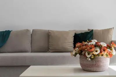 a living room with a couch and a vase with flowers at Vistahermosa 2 Rooms Piscina in El Puerto de Santa María