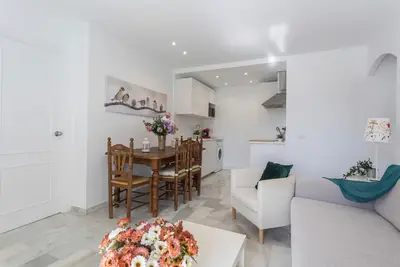 a living room and kitchen with a table and chairs at Vistahermosa 2 Rooms Piscina in El Puerto de Santa María