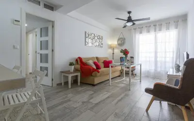 a living room with a couch and a table at Apartamentos Collado Playa Valdelagrana in El Puerto de Santa María